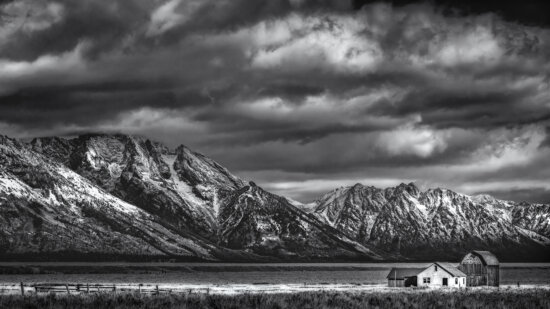 Light struggles to break through storm clouds over the Andy Chambers Homestead on Mormon Row, Grand Tetons National Park. BW Photography from Grand Tetons National Park, Wyoming by Craig McCord.